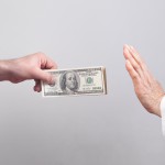 Caucasian doctor refusing money from patient